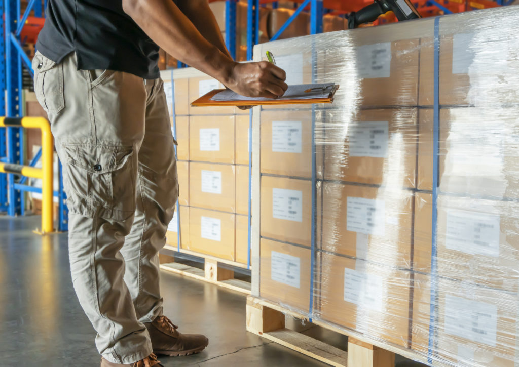 merchant checking the stocks of the delivered parcel in the warehouse